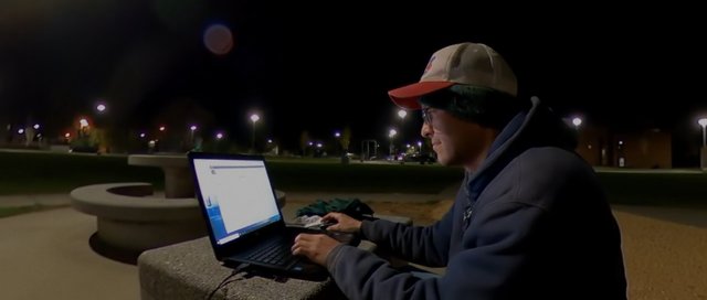 Persona con portátil de noche