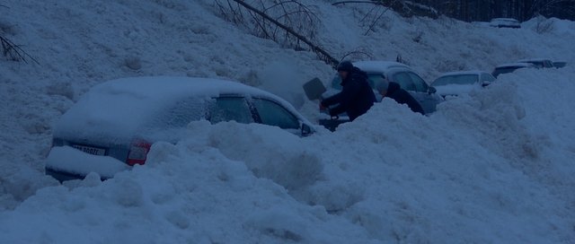 Persona entre coches y nieve
